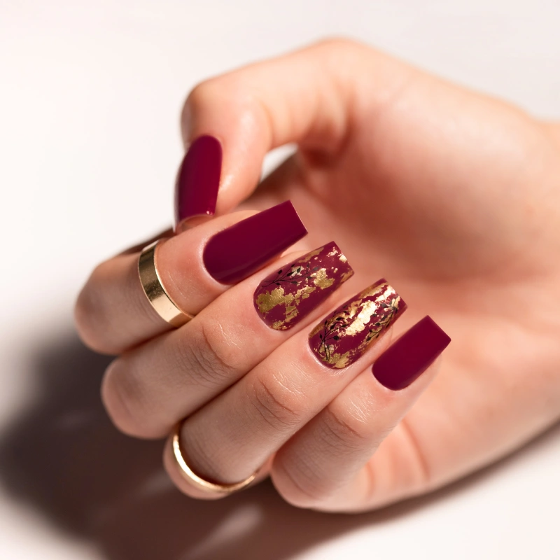 Burgundy nails with gold details and metallic flakes