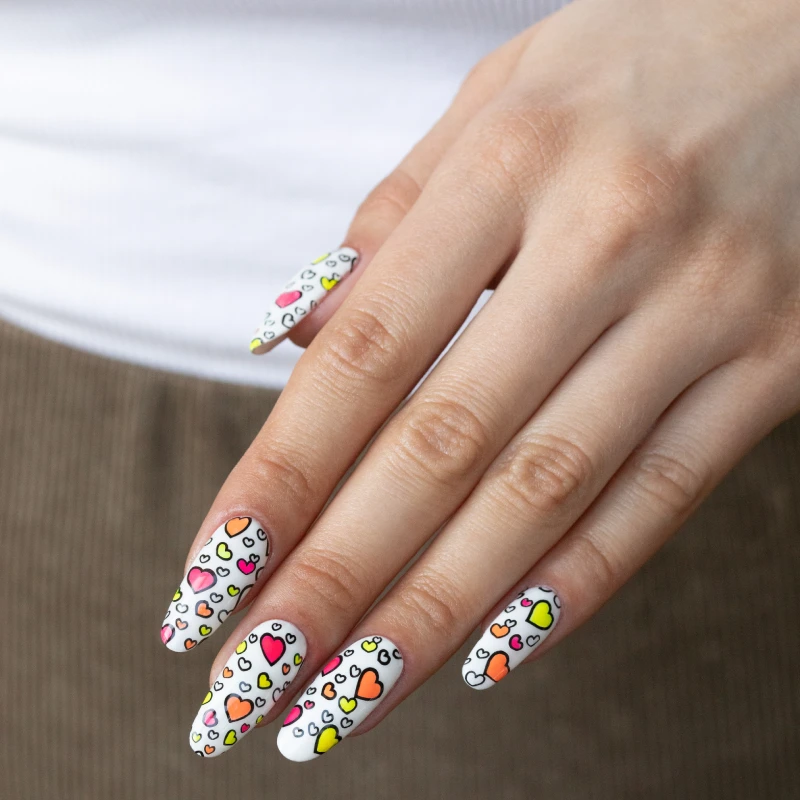 Almond nails with neon heart nail art on a white base