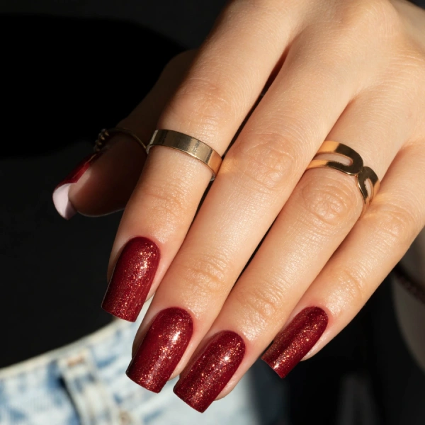 Red manicure with shimmering particles