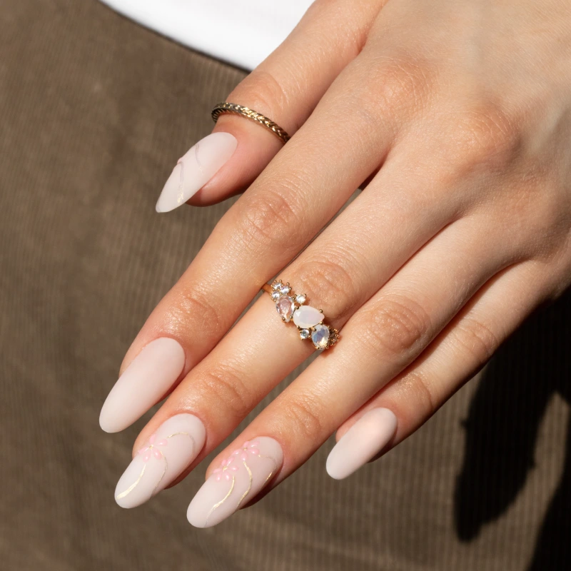 Light pink almond nails with delicate gold nail art