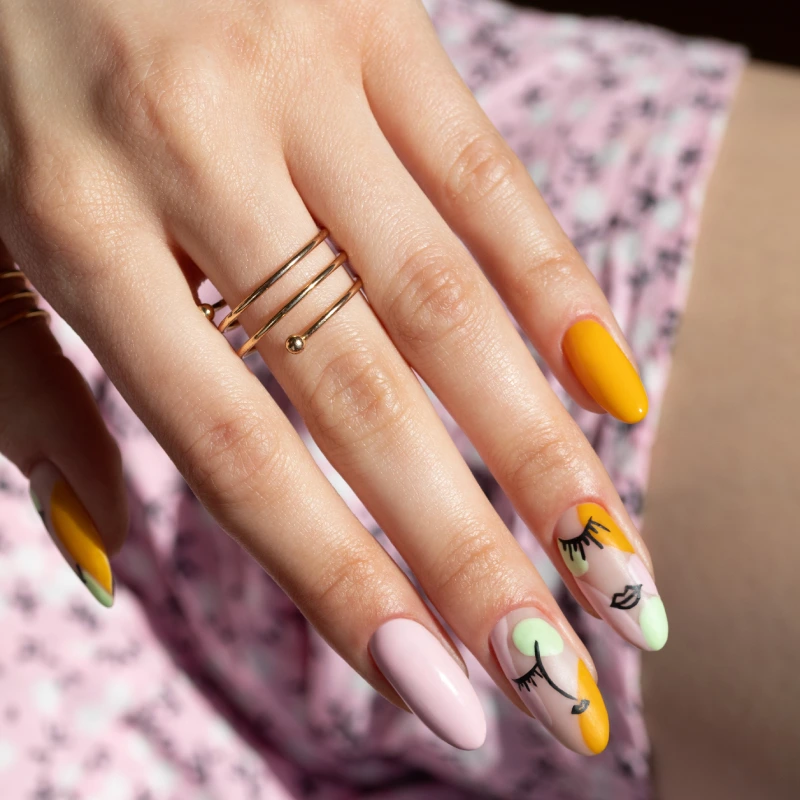 Line art manicure with a face motif and asymmetrical colour blocking