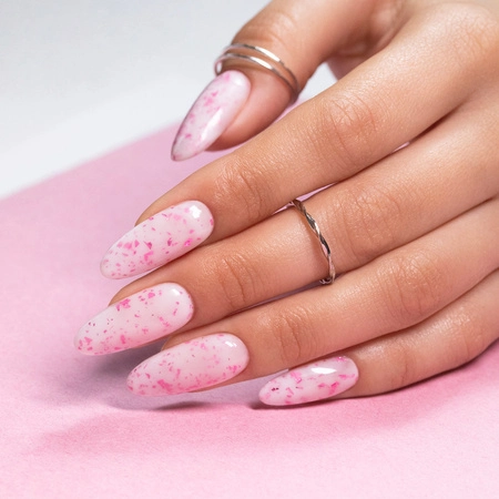 Mlecznoróżowy manicure na migdałowych paznokciach z drobnymi, metalicznymi płatkami w kolorze różowym