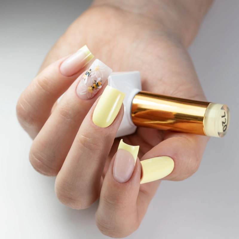 Spring yellow nails with hand-painted bees and floral nail art