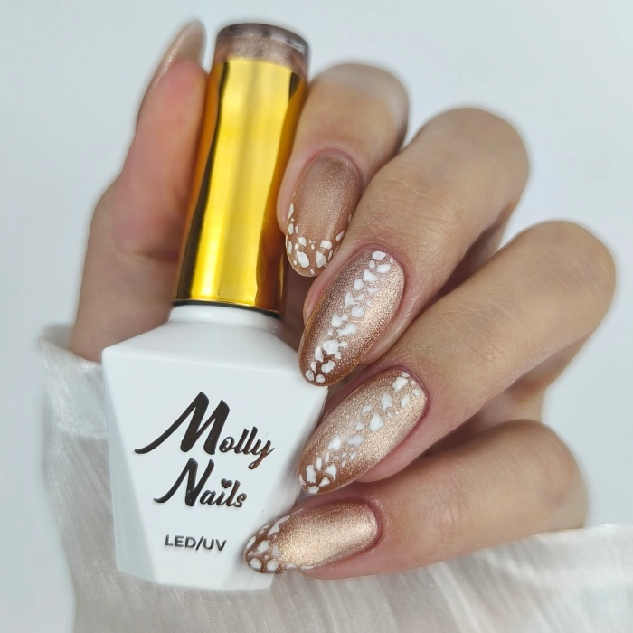 Ongles animal print dorés avec motif blanc inspiré de la peau de serpent et vernis Molly Nails