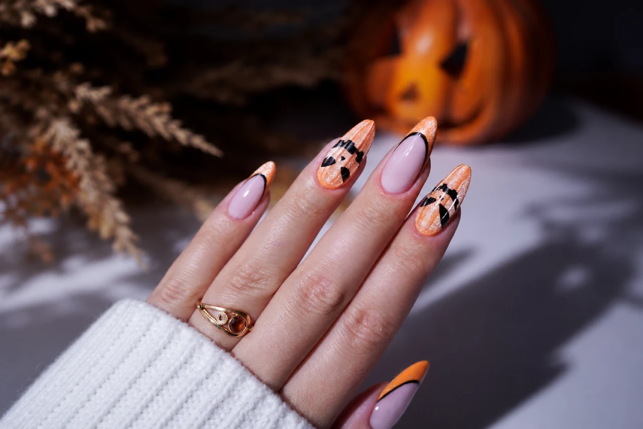 Orange Halloween nails with a pumpkin design