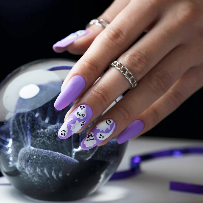 Halloween nails with white ghosts on a purple background