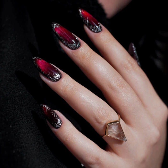 Red aura nail design with silver accents