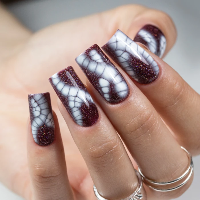 Ongles bordeaux avec motif reptile blanc inspiré de la peau des reptiles