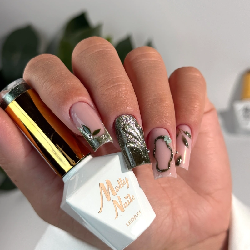 Green nails with leaves, metallic 3D details and a bottle of Molly Nails gel polish.