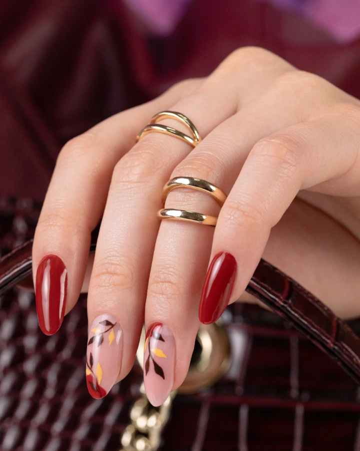 Burgundy red manicure with delicate floral nail art in warm autumn tones